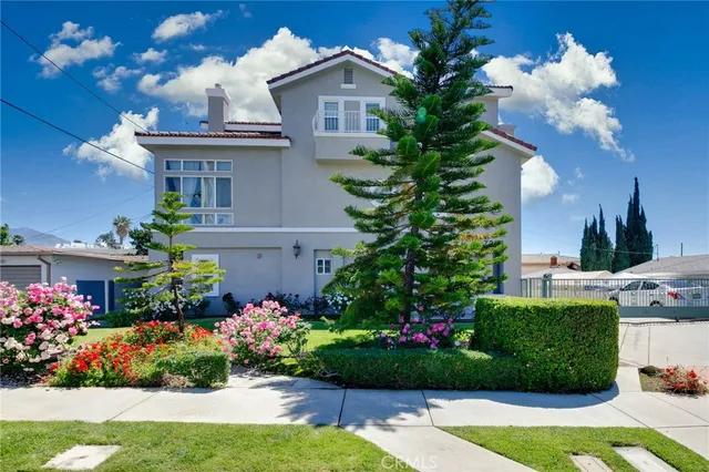 a front view of a house with a yard and a garden