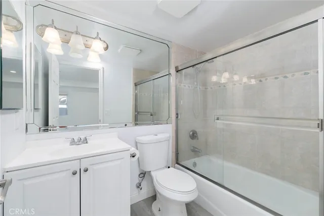 a bathroom with a sink a toilet and a large mirror