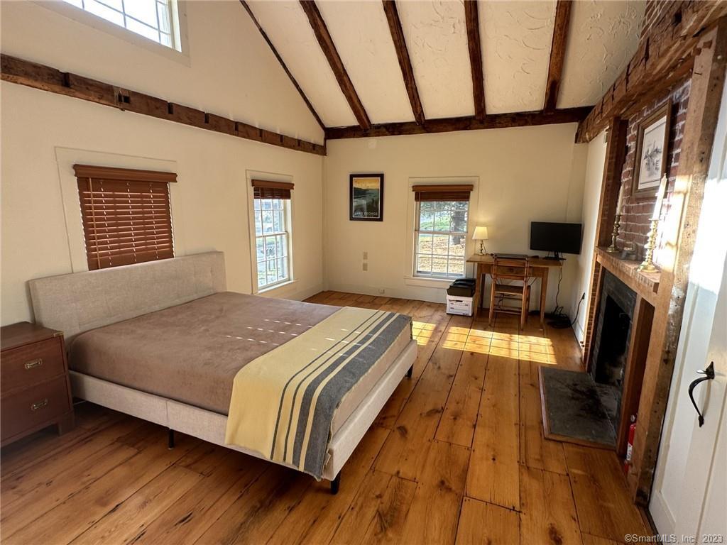 14 Quassuk Road, Unit 14 Woodbury, CT 06798 - Photo 13 of 23 a bedroom with a bed wooden floor and a fireplace