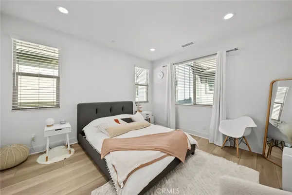 a bedroom with a bed a chandelier and a window