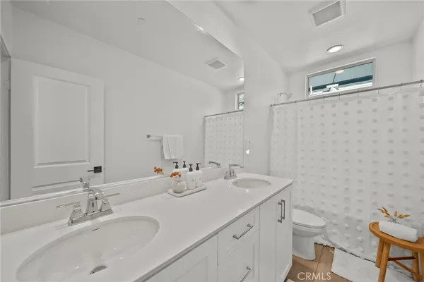 a bathroom with a double vanity sink toilet and a mirror