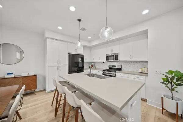 a kitchen with refrigerator cabinets dining table and chairs