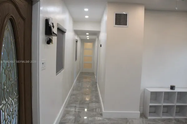 a view of a hallway with wooden shelves
