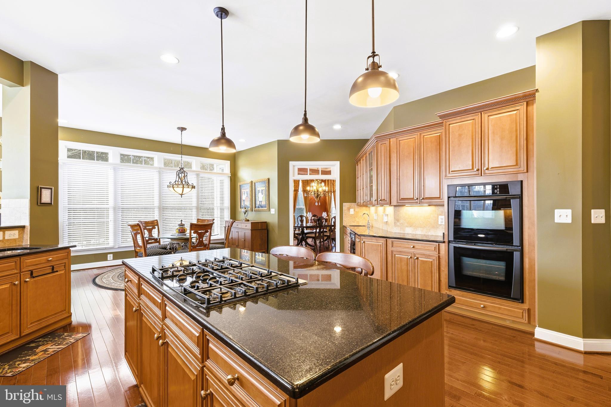 19606 Bellingham Lane Leesburg, VA 20175 - Photo 20 of 73 a kitchen with a stove a refrigerator a sink dishwasher with a dining table and chairs
