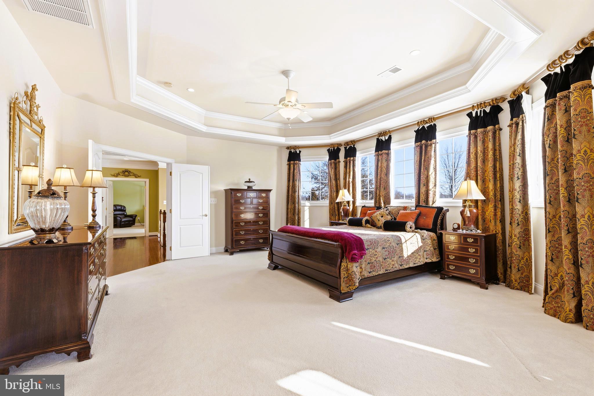 19606 Bellingham Lane Leesburg, VA 20175 - Photo 30 of 73 a spacious bedroom with a large bed and a chandelier