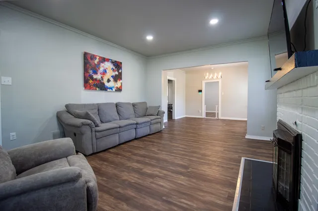 a living room with furniture a fireplace and a flat screen tv