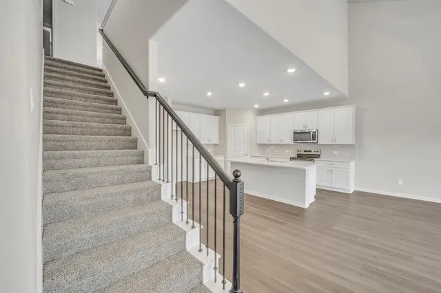 a view of entryway and kitchen with wooden floor