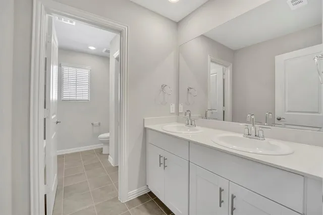 a spacious bathroom with a double vanity sink mirror and toilet