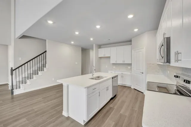 a kitchen with stainless steel appliances sink stove and cabinets