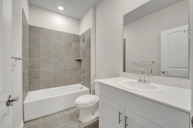 a bathroom with a bathtub shower sink vanity and toilet