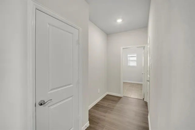 an empty room with wooden floor and closet area