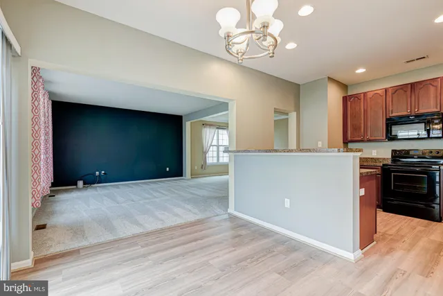 a kitchen with granite countertop a refrigerator stove and sink