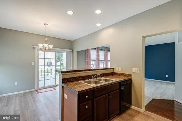 a view of an empty room with chandelier fan and a window
