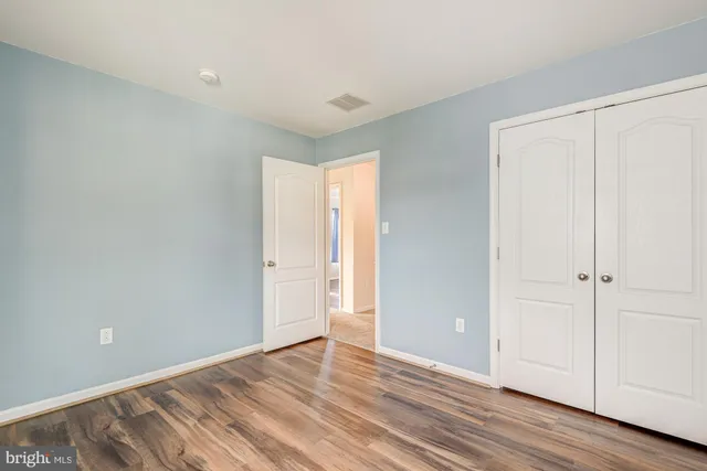 a view of an empty room and window and wooden floor
