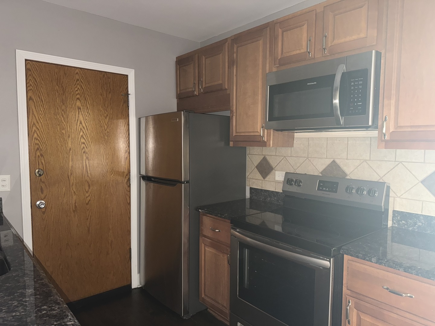 5041 North East River Road, Unit 3A Norridge, IL 60706 - Photo 6 of 12 a kitchen with stainless steel appliances granite countertop a refrigerator and a microwave