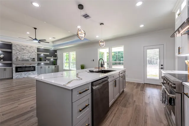 a large kitchen with stainless steel appliances a large counter space a sink and appliances