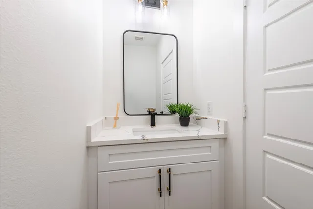 a bathroom with a sink vanity and a mirror