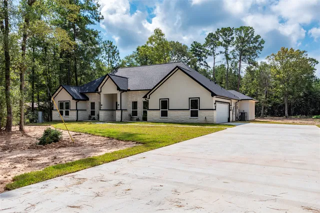 a view of a house with backyard and trees