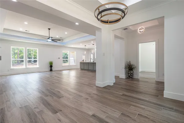 a view of a kitchen with kitchen island a sink wooden floor and stainless steel appliances