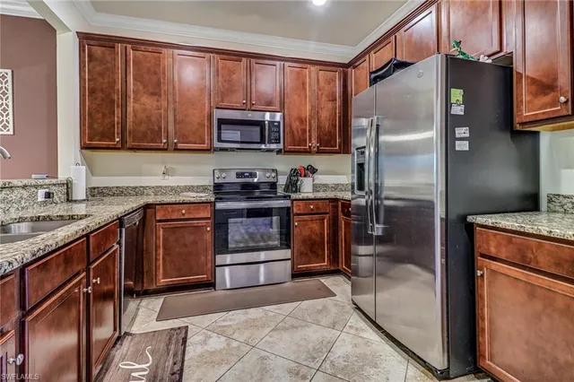 a kitchen with stainless steel appliances granite countertop a refrigerator a stove a sink and dishwasher