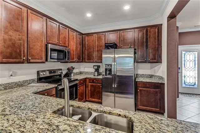 a kitchen with stainless steel appliances granite countertop wooden cabinets a stove a sink and a granite counter top