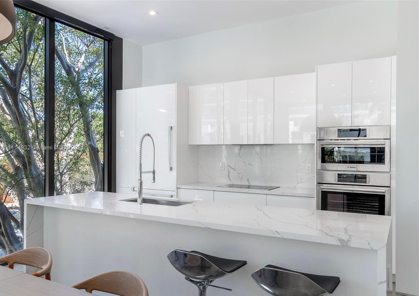 1525 Bay Road Miami Beach, FL 33139 - Photo 3 of 13 a kitchen with granite countertop a stove a sink and a microwave