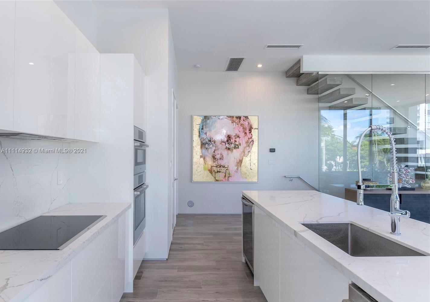 1525 Bay Road Miami Beach, FL 33139 - Photo 4 of 13 a view of cabinets and kitchen countertops with wooden floor