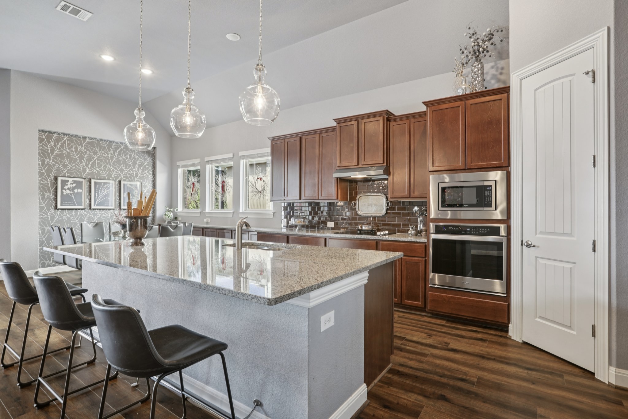 210 Barton Run Drive Georgetown, TX 78628 - Photo 13 of 40 a kitchen with stainless steel appliances granite countertop a stove top oven a sink dishwasher a dining table and chairs with wooden floor