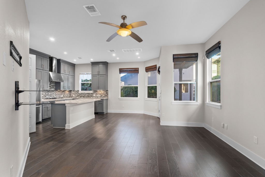 1004 Banyon Street Austin, TX 78757 - Photo 6 of 33 a kitchen with stainless steel appliances kitchen island hardwood floor sink stove and wooden cabinets