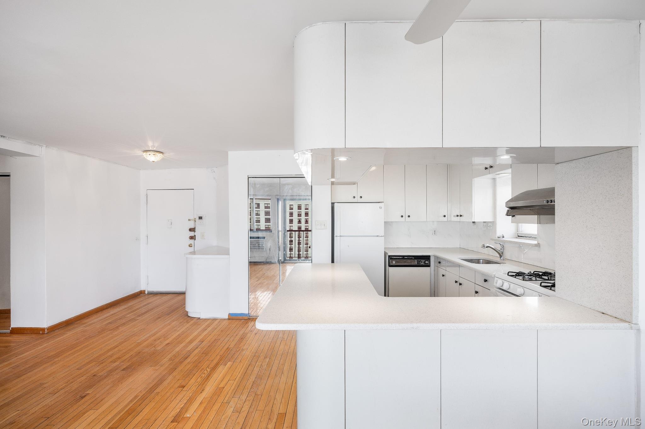 133-36 41st Road, Unit 8F Queens, NY 11355 - Photo 7 of 18 Kitchen / Open Living Area – The open kitchen features generous counter space, ample cabinetry, and a convenient breakfast bar that overlooks the main living area. Stainless steel appliances and a functional layout create an ideal space for both everyday cooking and casual dining.