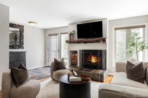 a living room with furniture a flat screen tv and a fireplace