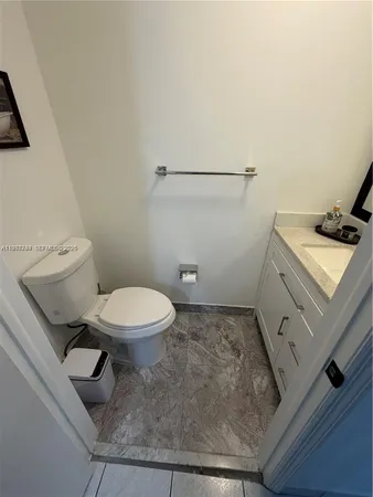 a bathroom with a granite countertop toilet and a sink