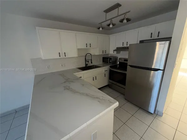 a kitchen with a refrigerator sink and microwave