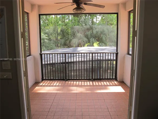 a view of a chairs and table in the patio next to a yard
