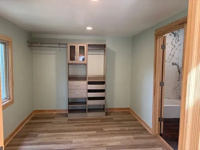 a view of walk in closet with wooden floor
