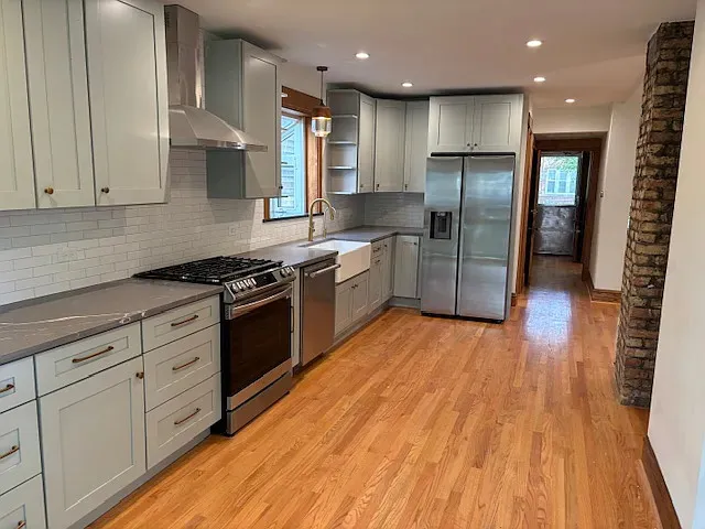 a kitchen with stainless steel appliances granite countertop a stove a sink and a refrigerator