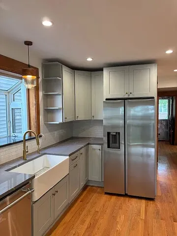 a kitchen with stainless steel appliances granite countertop a refrigerator a sink and a stove