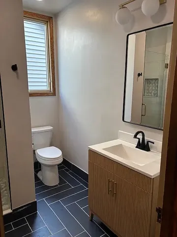 a bathroom with a toilet sink and mirror