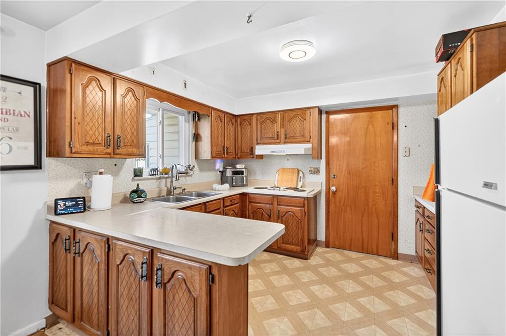 717 Mercer Road Beaver Falls, PA 15010 - Photo 6 of 22 a kitchen that has a sink a refrigerator and cabinets