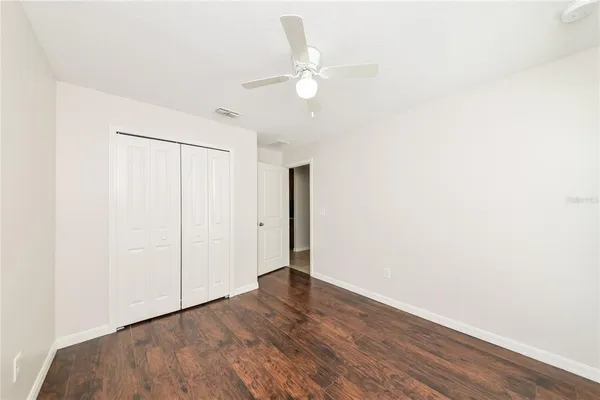 a view of an empty room with wooden floor