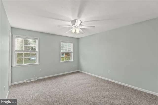 an empty room with a chandelier fan and a chandelier fan
