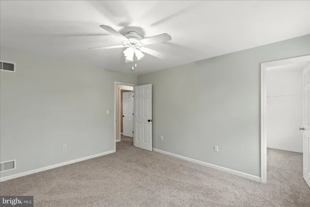 an empty room with a window and a fan