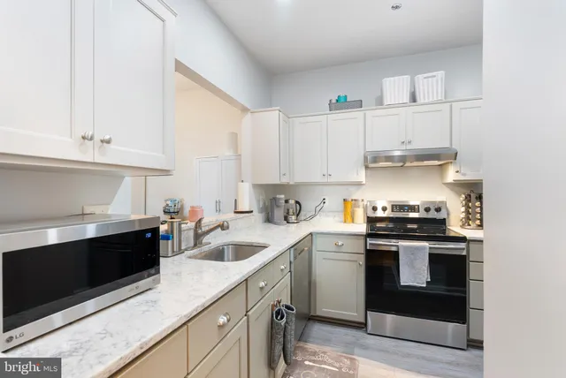 a kitchen with stainless steel appliances granite countertop a sink and stove top oven