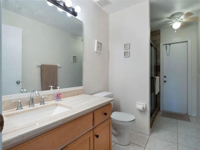 a bathroom with a granite countertop sink a toilet and a mirror