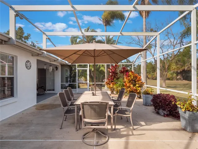 a view of a patio with table and chairs under an umbrella