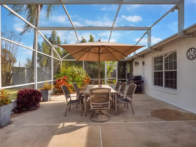 a view of a patio with a table and chairs under an umbrella