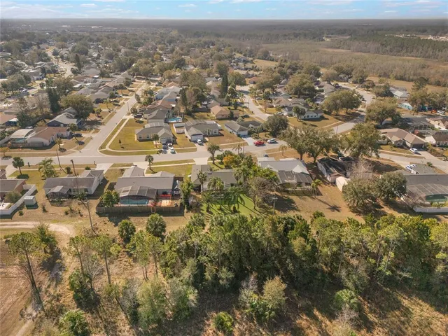 an aerial view of residential houses with outdoor space and swimming pool