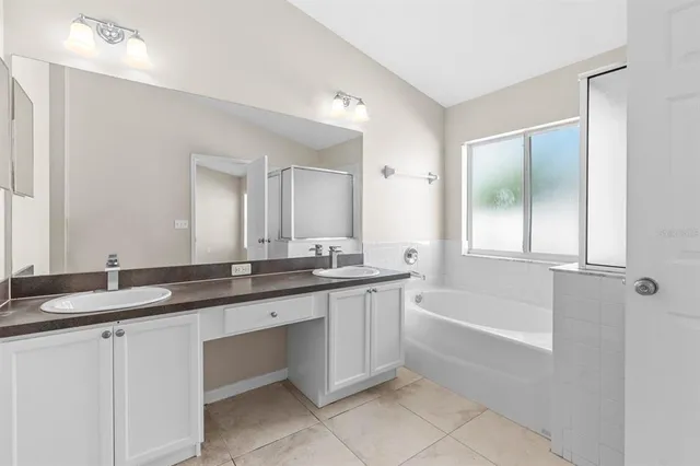 a bathroom with a granite countertop sink mirror and a bathtub