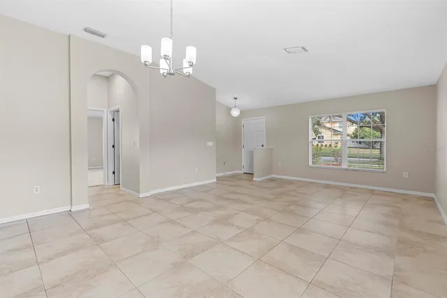 an empty room with kitchen and windows