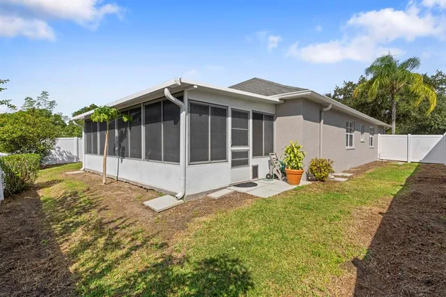 a view of a house with a yard and potted plants
